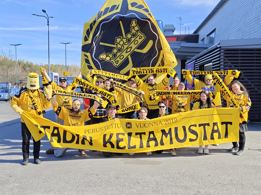 Stadin Keltamustat katsomossa keltaisissa huiveissa
